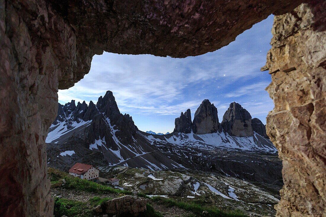 The Three Peaks of Lavaredo seen from a cave at night. Sesto Dolomites Trentino Alto Adige Italy Europe.