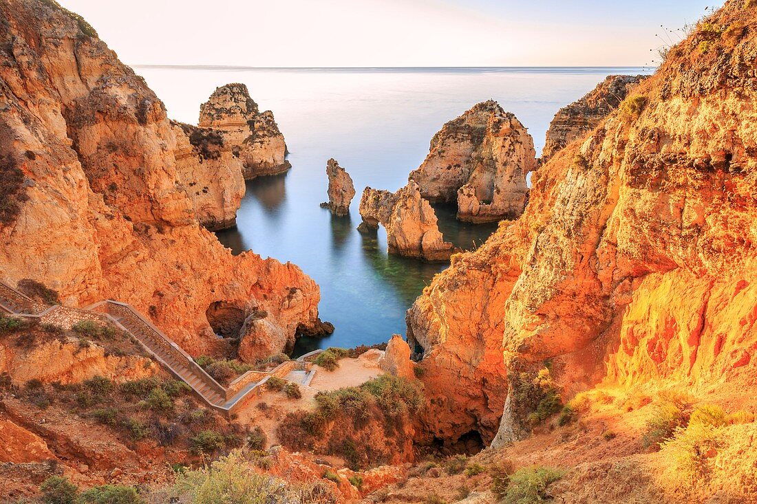 Golden sunrise on the red cliffs of Ponta da Piedade Lagos Algarve Portugal Europe.