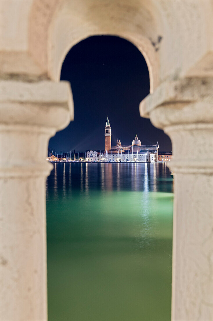 glimpse of the island of San Giorgio Maggiore framed between the columns of a bridge, Venice, Veneto, Italy