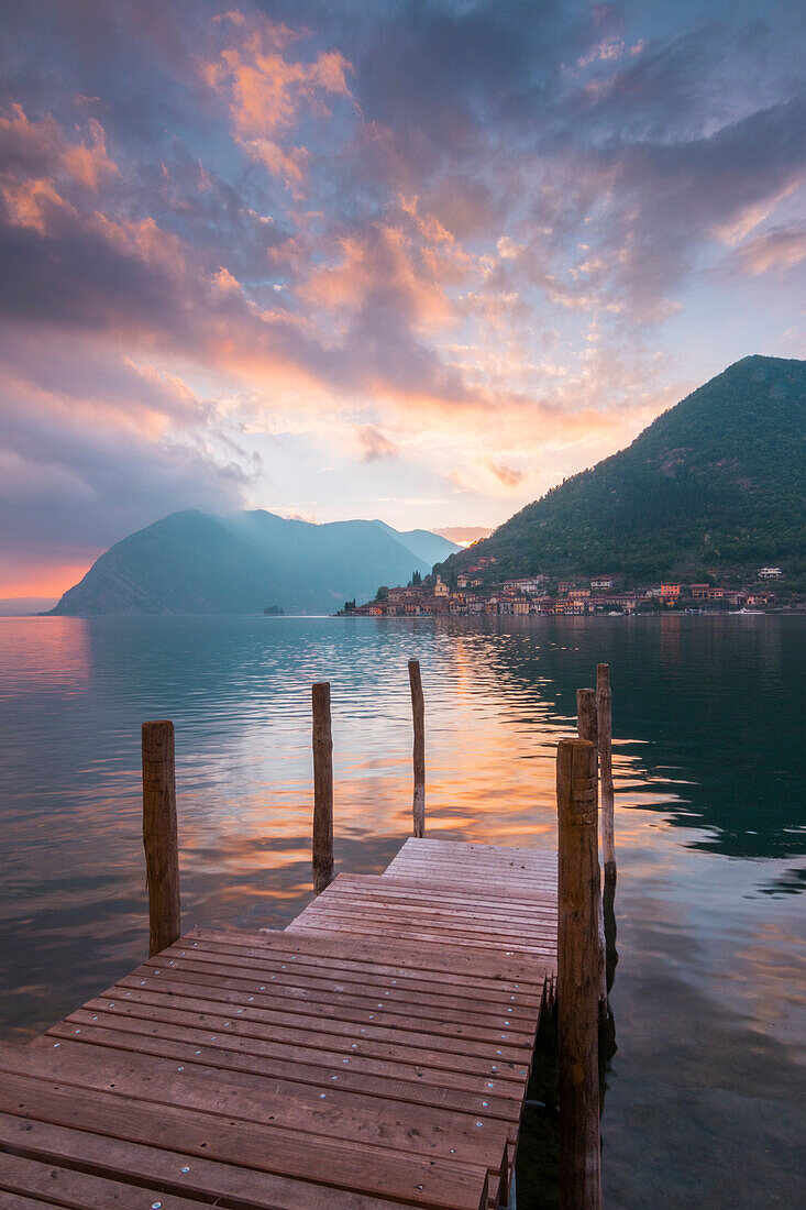 A pier in the lake toward Peschiera Maraglio at sunset, Montisola, Iseo lake, Brescia province, Lombardy district, Italy