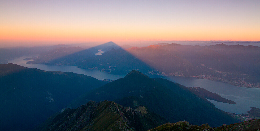 The shadow, with a pyramid form, of Legnone mount over Como lake, Lombardy, Italy