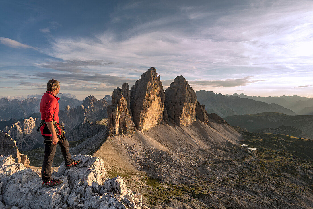 Sesto / Sexten, province of Bolzano, Dolomites, South Tyrol, Italy. A mountaineer admires the sunset at the Three Peaks of Lavaredo