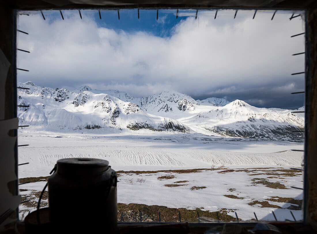 View of Canwell Glacier through the bear-resistant window of the Lower Canwell Hut; Alaska, United States of America