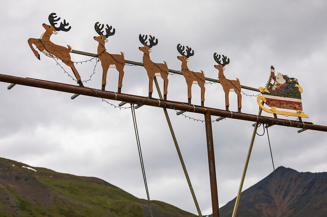This out-of-place decorative scene of Santa Claus with his reindeer sleigh is attached to a light post at the Alaska DOT Chandalar Maintenance Camp along the Dalton Highway; Alaska, United States of America