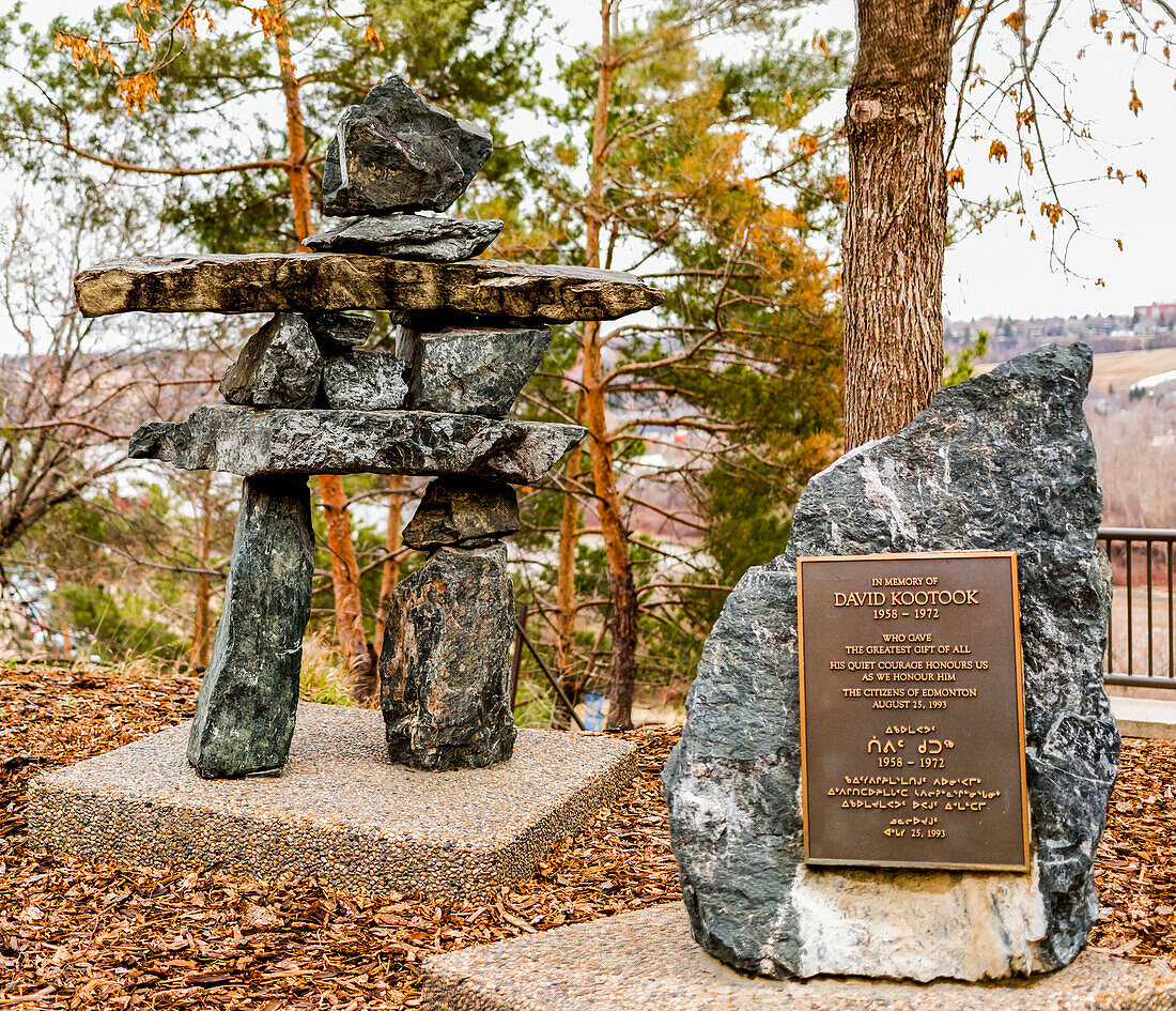 A memorial plaque with inukshuk among some trees in autumn; Edmonton, Alberta, Canada