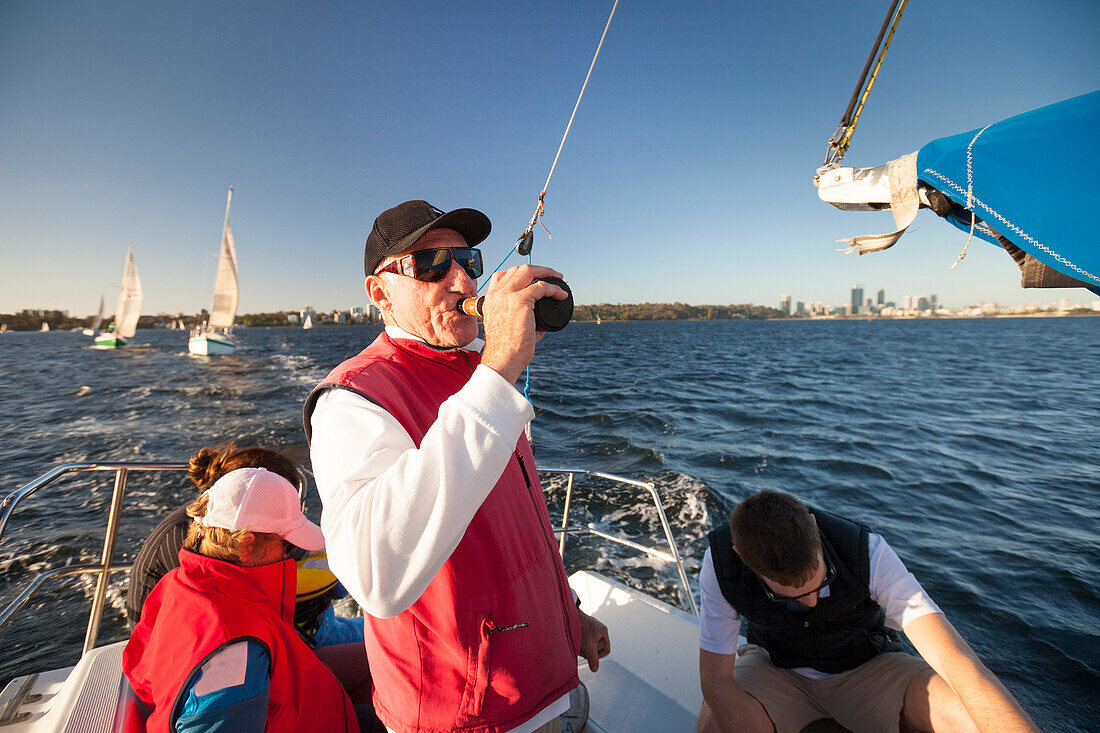 Sailor drinking beer while sailing, Perth, Western Australia, Australia