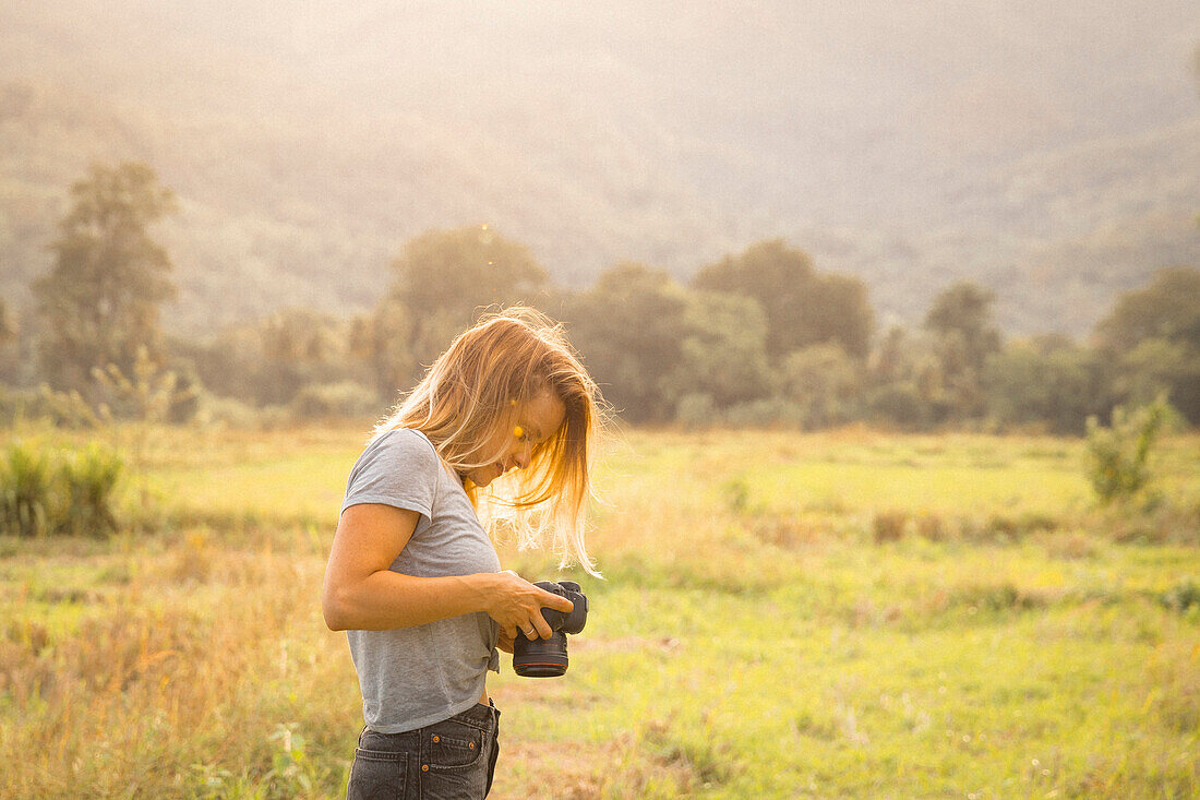 Woman checking camera in nature, Wellawaya, Uva Province, Sri Lanka