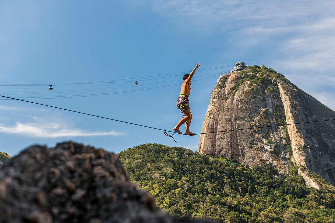 Side view of man highlining in Contos De Pescadores, Vermelha Beach, Rio de Janeiro, Brazil