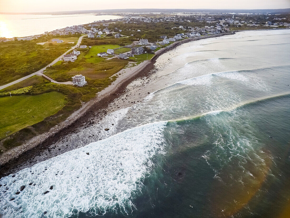 An aerial drone photograph of large hurricane swell sweeping up the coast in long lines during sunset at Point Judith, Rhode Island, from Hurricane Jose