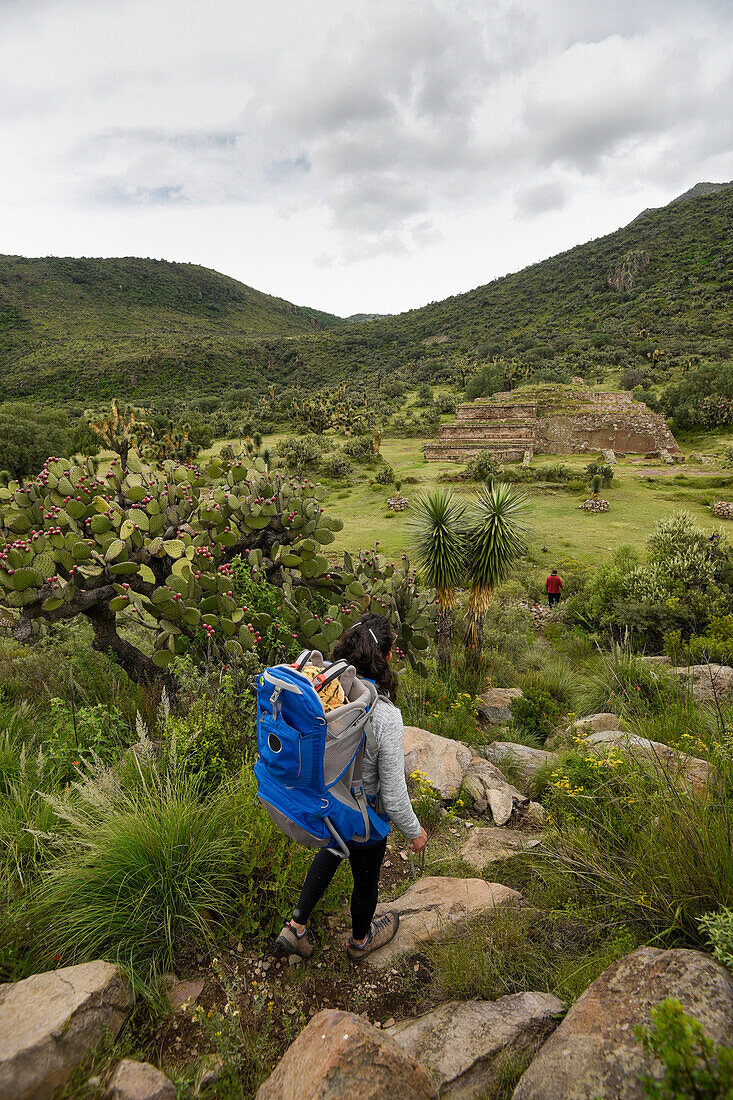 One woman with blue backpack hiking at Xihuingo archeological area at Tepeapulco, Hidalgo, Mexico