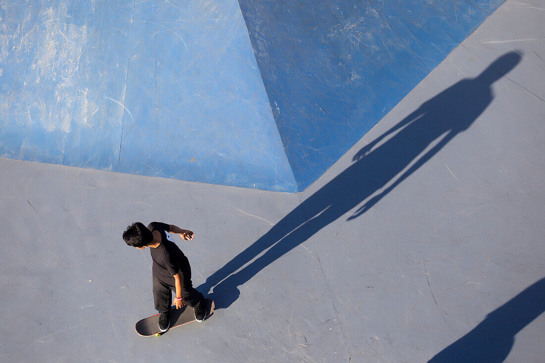 View from above of teenage boy skateboarding in skate park, Canggu, Bali, Indonesia