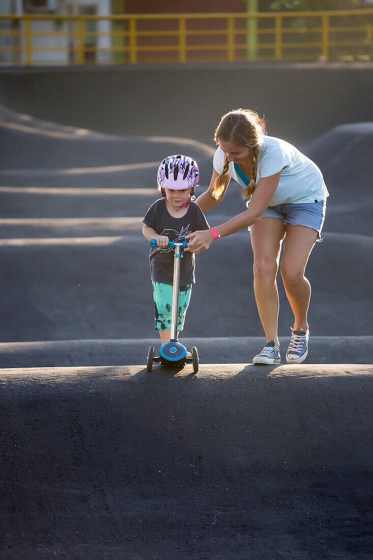 Mother and son with push scooter in skate park, Canggu, Bali, Indonesia