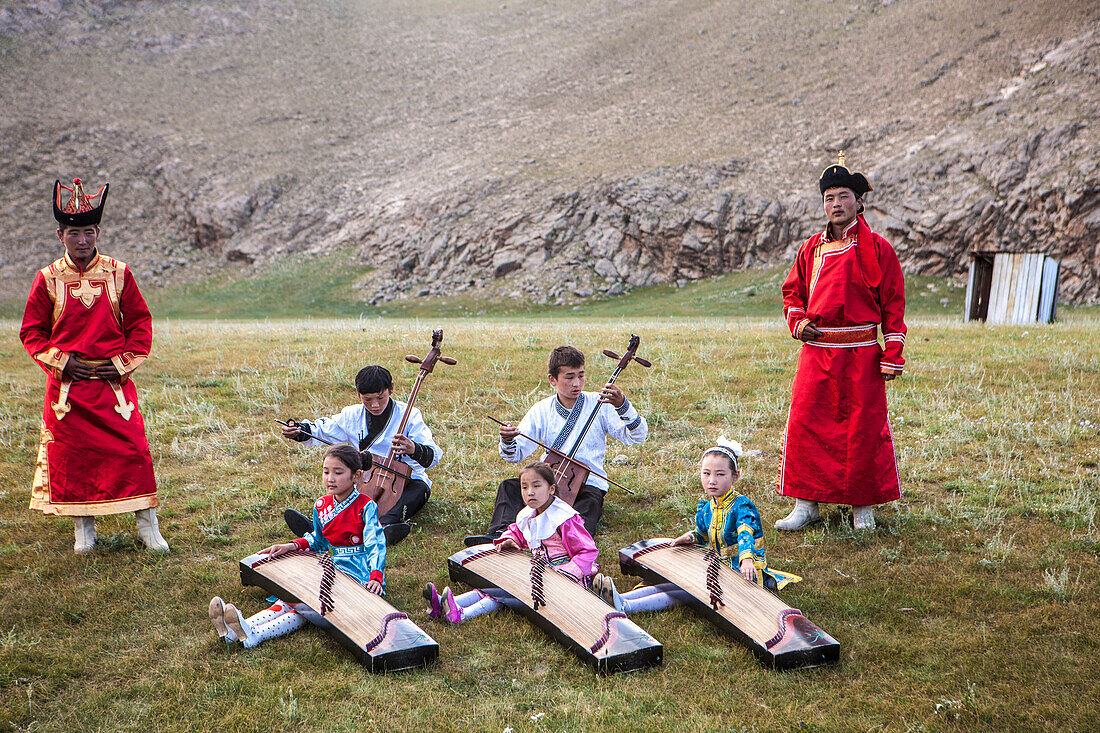Boys playing Morin khuur (stringed instrument) (horse-head-violin) while young girls play Yatga-Yatuga (stringed instrument), Bunkhan, Mongolia, Central Asia, Asia