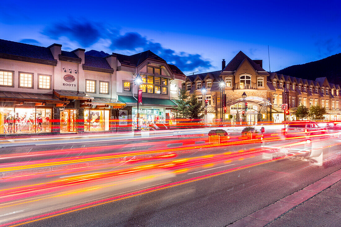 Trail lights and shops on Banff Avenue at dusk, Banff, Banff National Park, Alberta, Canada, North America