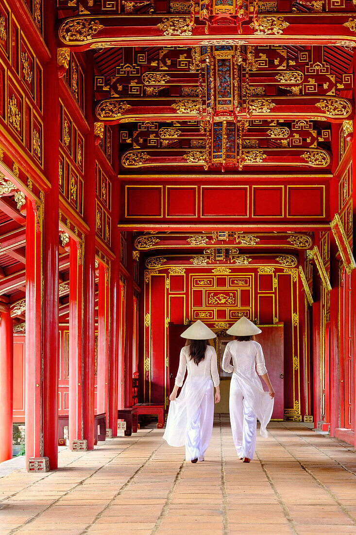 Two women in traditional Ao Dai dress and Non La conical hats in the Forbidden Purple City of Hue, UNESCO World Heritage Site, Thua Thien Hue, Vietnam, Indochina, Southeast Asia, Asia