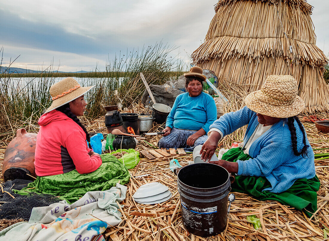 Native Uro Family preparing a meal, Uros Floating Islands, Lake Titicaca, Puno Region, Peru, South America