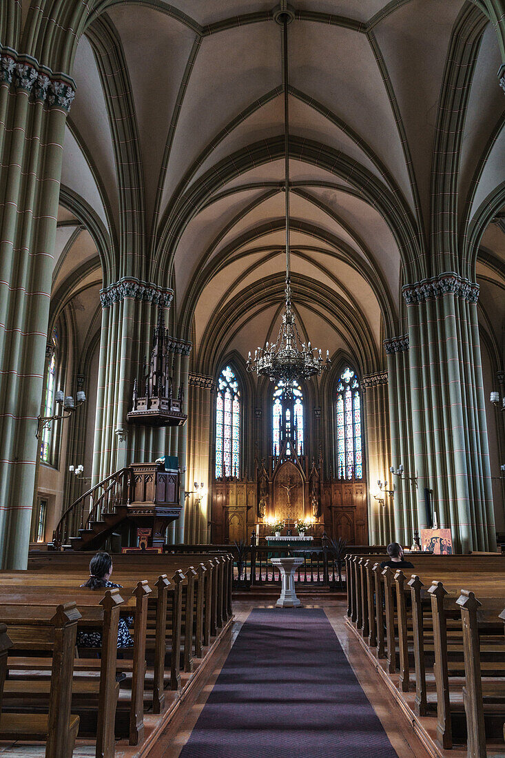 Nave of St. Gertrude Old Church, worshipper in pew, Riga, Latvia, Europe