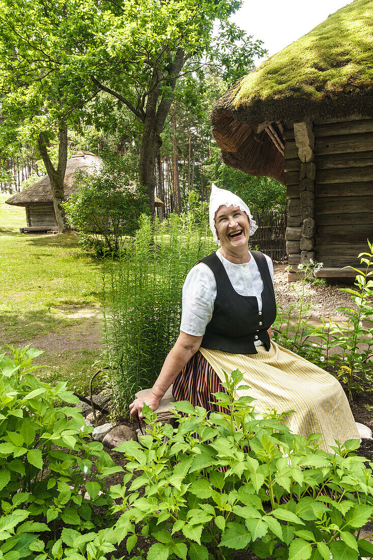 Woman in traditional dress outside a 17th century farmstead, Latvian Ethnographic Open Air Museum, Riga, Latvia, Europe