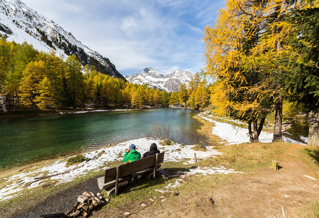 People on a bench on the shore of Lai da Palpuogna (Palpuognasee), Bergun, Albula Pass, Canton of Graubunden (Grisons), Switzerland, Europe