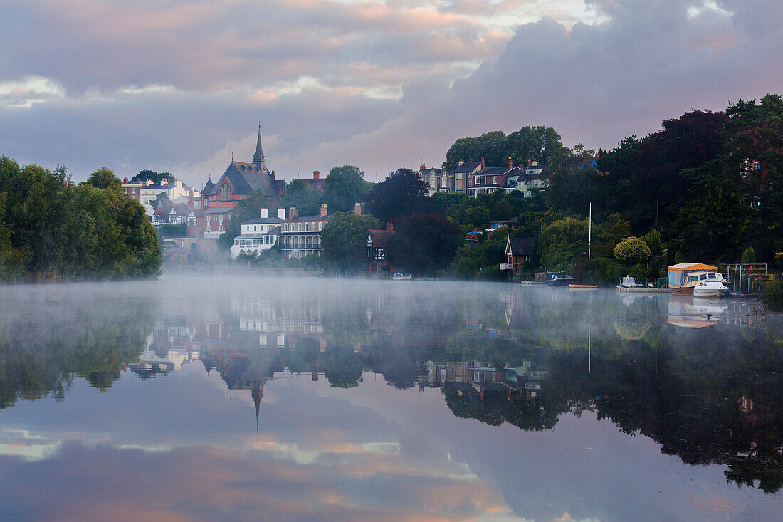 Early morning mist settles on the River Dee with boats and buildings reflected in the still water, Chester, Cheshire, England, United Kingdom, Europe