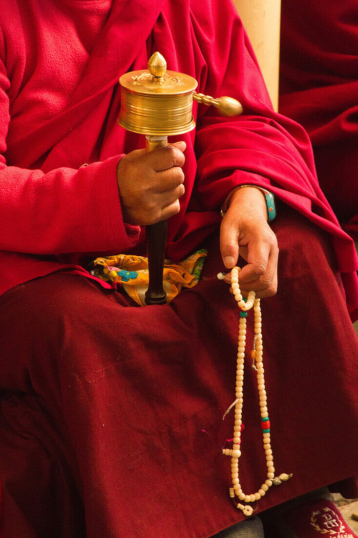 Tibetan Buddhist monk with prayer wheel and beads at Losar (Tibetan New Year) in the Dalai Lama Temple, McLeod Ganj, Dharamsala, Himachal Pradesh, India, Asia