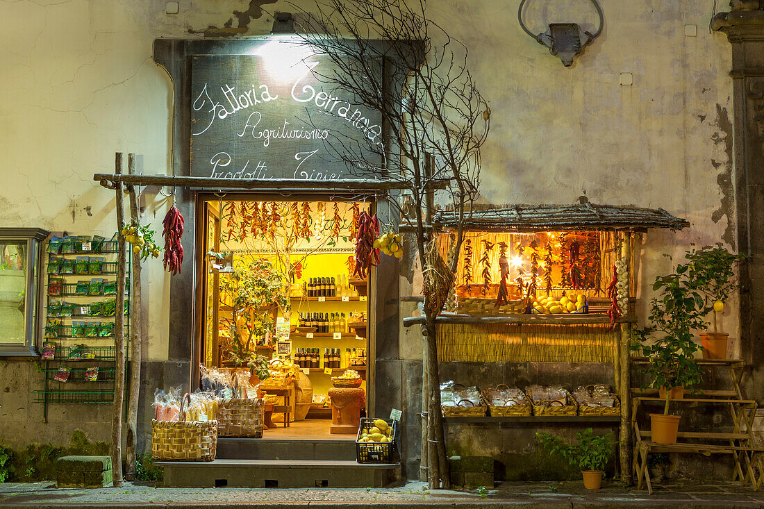 Shop lit up selling produce at night in the back streets of Sorrento, Campania, Italy, Europe