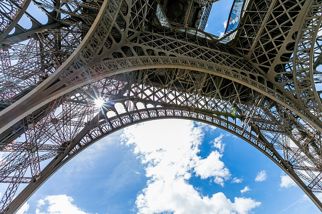 Sunbeams through metal beams of Eiffel Tower, Paris, Ile de France, France