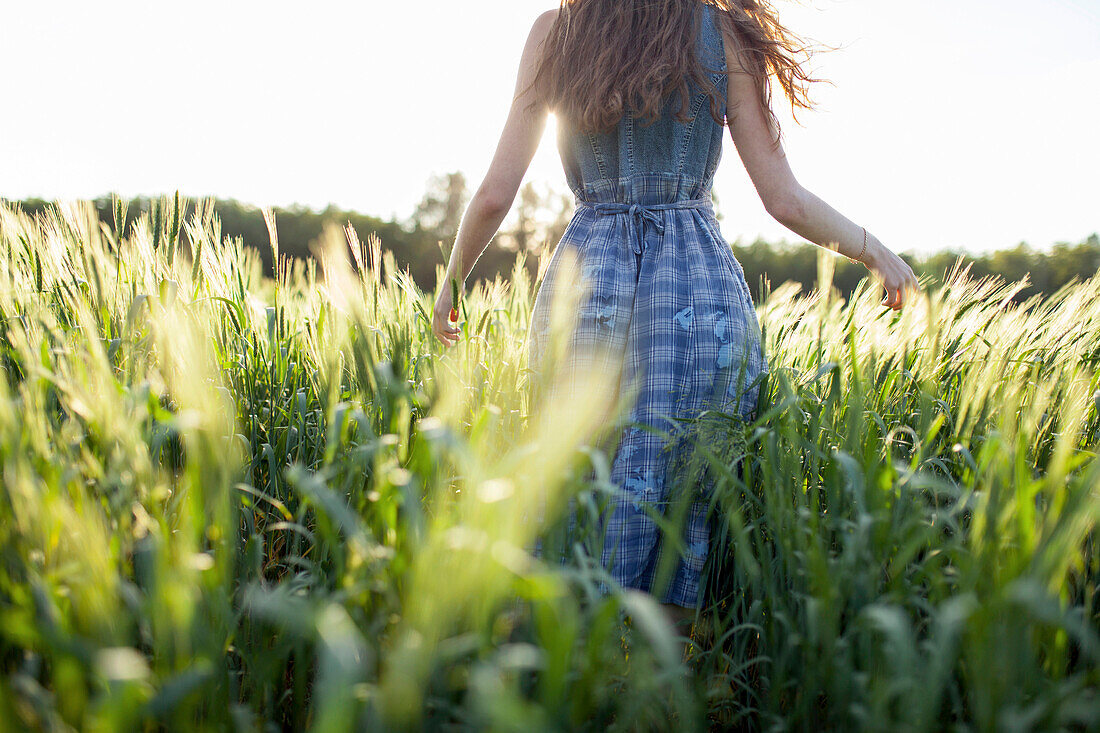 Caucasian woman walking in field of tall grass