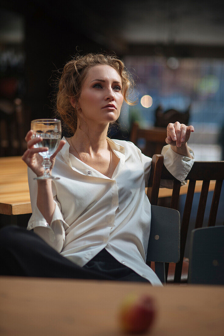 Caucasian woman sitting at table drinking water