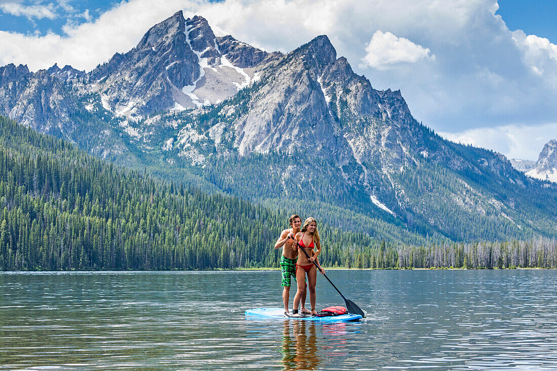 Caucasian couple on paddleboard in lake