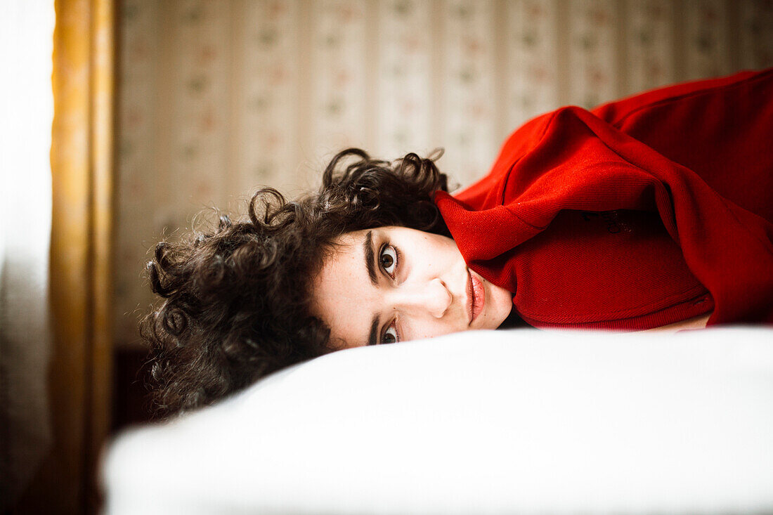 Porträt einer ernsten kaukasischen Frau auf dem Bett liegend