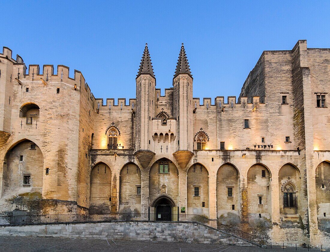 Evening light over the Gothic twin towered facade of the Palais Neuf, Palais des Papes, Palace Square, Avignon, Vaucluse, Provence-Alpes-Cote d'Azur, France.