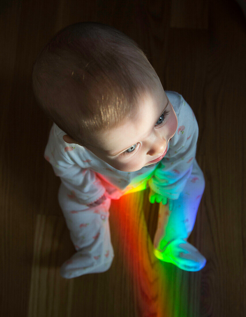 High Angle View of Baby Sitting on Floor with Rainbow