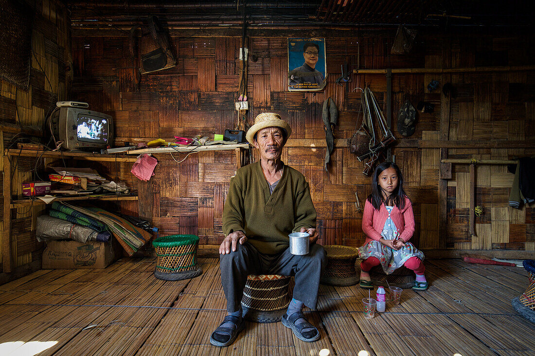 Familie in traditioneller Holzhütte, Arunachal, Indien, Asien