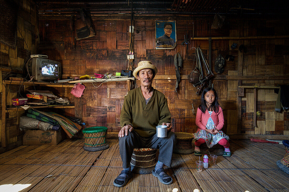 Family in traditional wooden hut, Arunachal, India, Asia