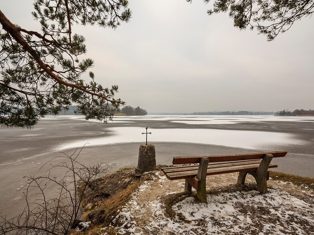 Viewpoint with cross on the shore of the frozen Staffelsee, Seehausen, Upper Bavaria, Germany
