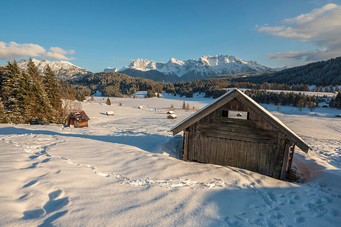 Blick auf die verschneiten Hütten am gefrorenen Geroldsee, im Hintergrund das Karwendelgebirge, Gerold, Oberbayen, Deutschland