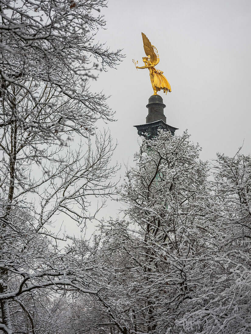 View of the Friedensengel through the snowy trees, Munich, Upper Bavaria, Germany