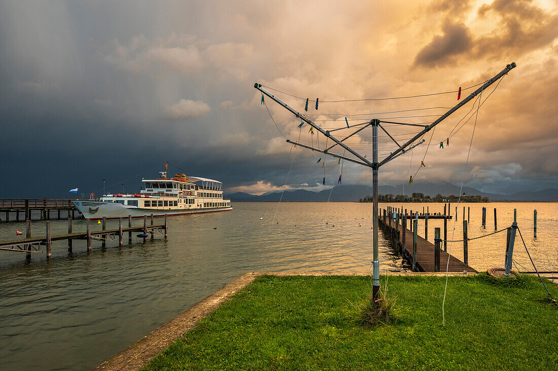 Gewitterstimmung am Hafen von Gstadt mit Blick auf die Fraueninsel und die Chiemgauer Alpen, Gstadt am Chiemsee, Oberbayern, Deutschland