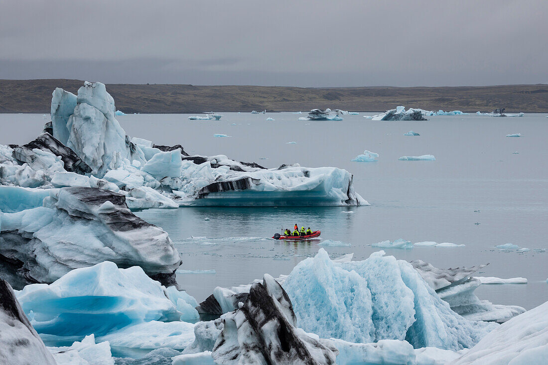 Boat amongst calved ice from the Breidamerkurjokull glacier in Jokulsarlon glacial lagoon, Iceland, Polar Regions