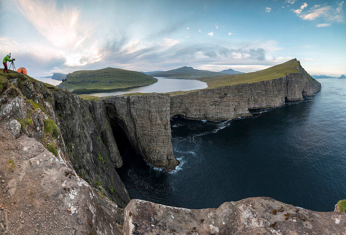 Panoramic of photographer on cliffs above lake Sorvagsvatn, Vagar Island, Faroe Islands, Denmark, Europe