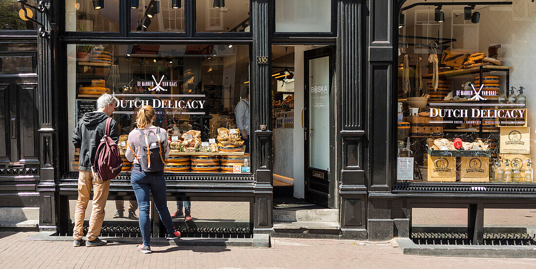 Tourists looking at display of food shop in Amsterdam, Netherlands, Europe