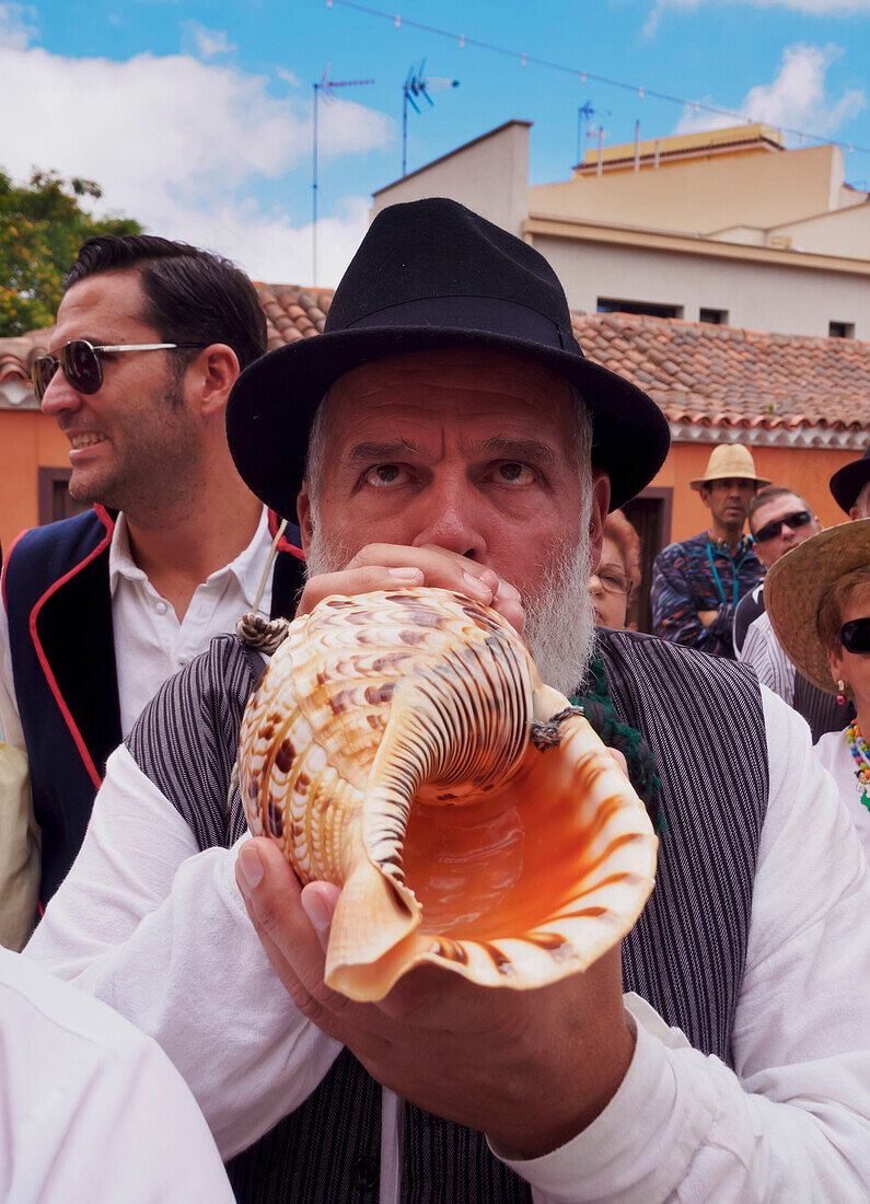 Man blowing conch shell, Romeria de San Benito de Abad, traditional street party, San Cristobal de La Laguna, Tenerife Island, Canary Islands, Spain, Europe