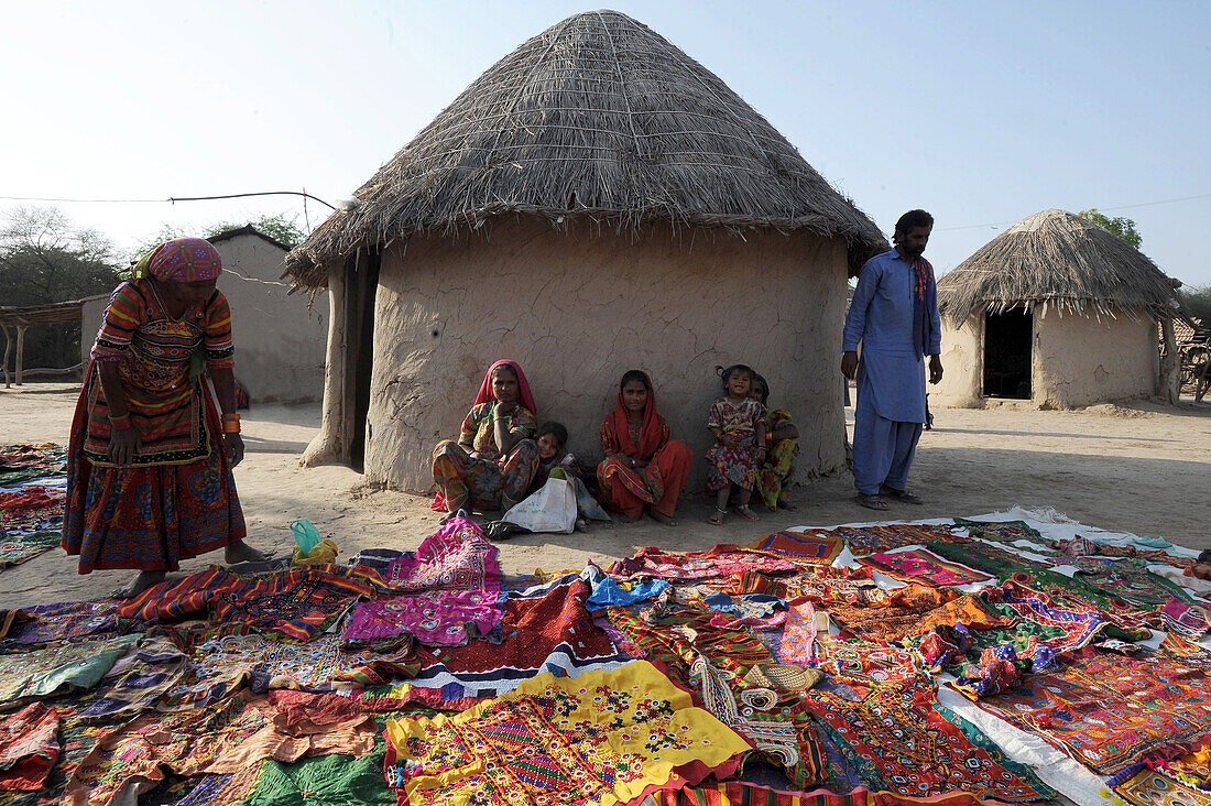 Pathan tribal family in front of traditional mud house (bhunga), showing their colourful tribal embroidery, Jarawali, Kutch, Gujarat, India, Asia
