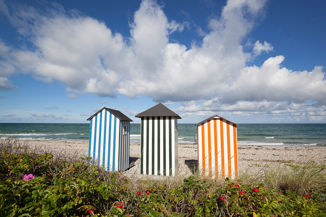 Colourful beach huts on pebble beach with blue sea and sky with clouds, Rageleje, Kattegat Coast, Zealand, Denmark, Scandinavia, Europe