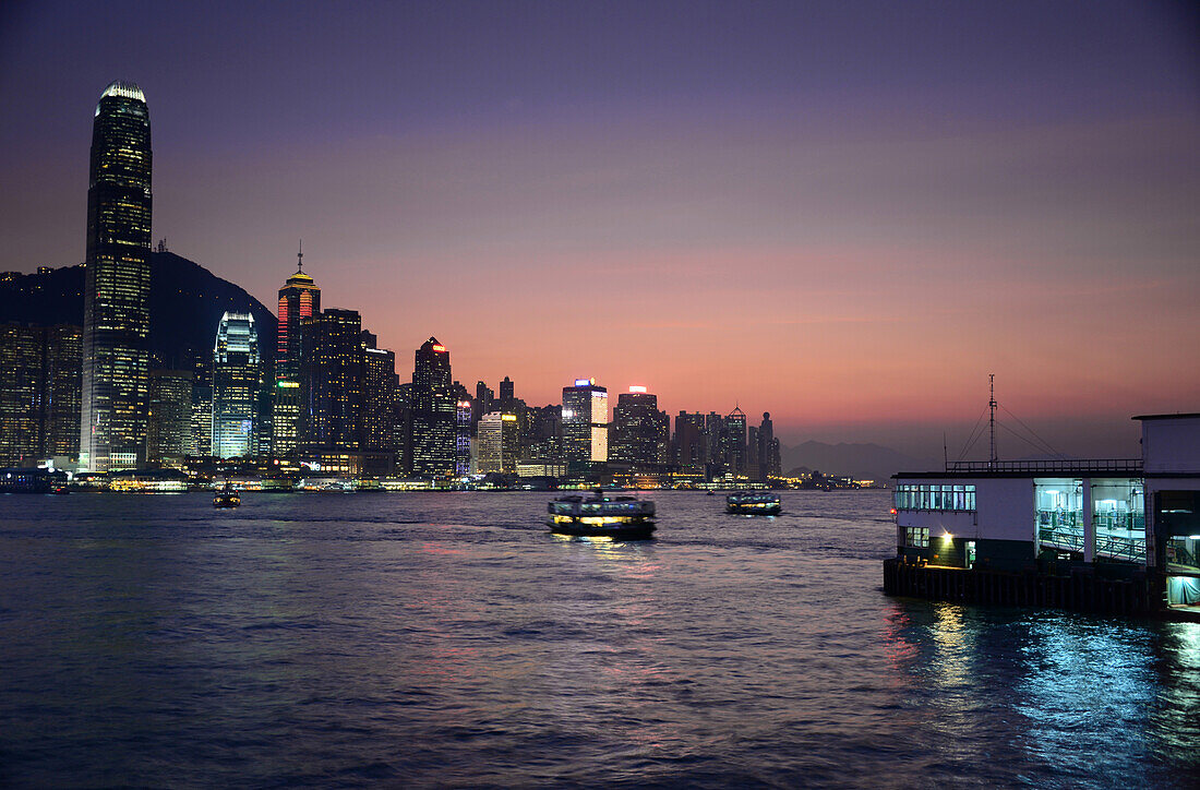Abend Blick auf Victoria Island mit Starferry von der Promenade auf Kowloon, Hongkong, China
