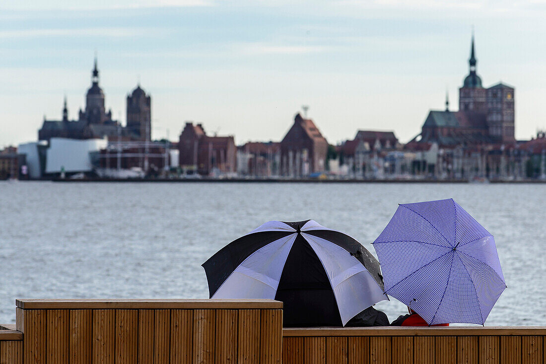 Blick auf Altstadt mit Menschen mit Regenschirmen davor. Stralsund, Ostseeküste, Mecklenburg-Vorpommern, Deutschland