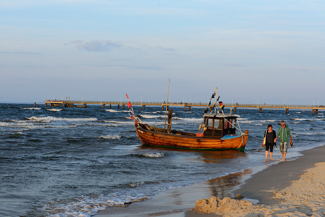 Menschen und kleines Fischerboot aus Holz  am Strand von  Ahlbeck, Usedom, Ostseeküste, Mecklenburg-Vorpommern, Deutschland