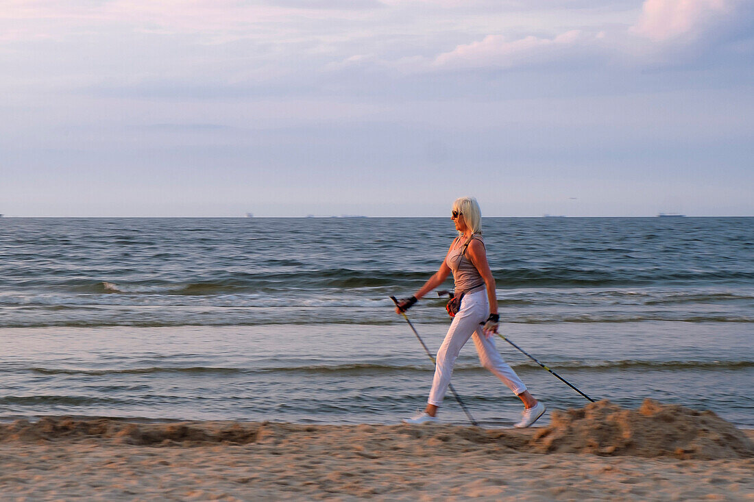 Blonde Frau macht Nordic Walking am Strand von Swinemünde, Ostseeküste, Polen Deutschland Blond woman makes nordic walking at the beach of Swinoujende, Baltic Sea coast, Poland Germany