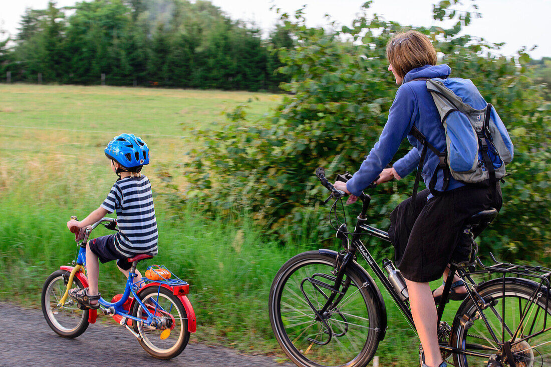 Mother with child cycling on a dirt road, Usedom, Ostseeküste, Mecklenburg-Vorpommern, Germany